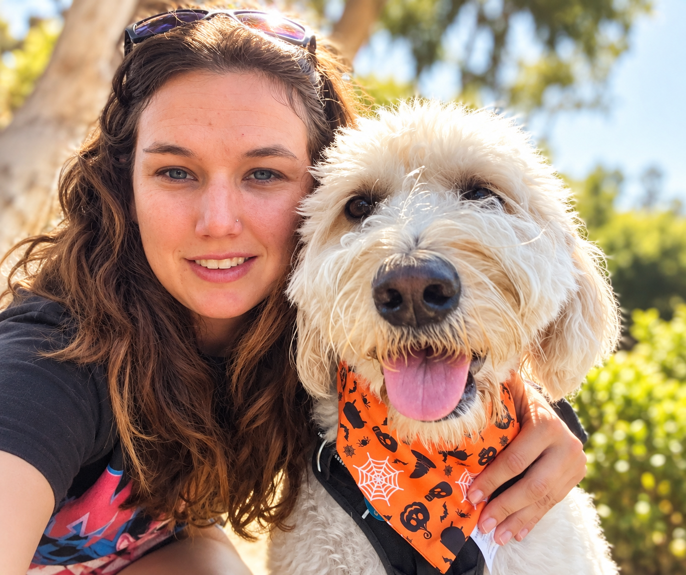 Avela, pet sitter and dog walker in Ventura County, outdoors with a happy fluffy dog